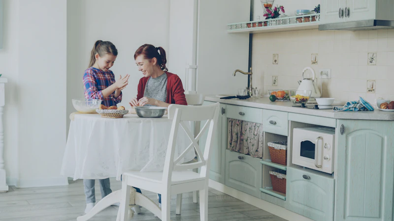 A mother and daughter baking together at a kitchen table